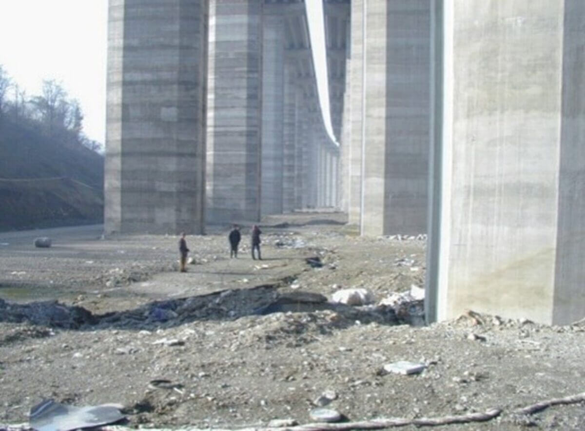 Three engineers standing next to enormous stone columns